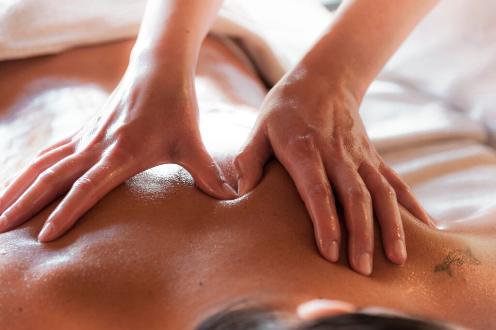 Professional massage therapist's hands performing therapeutic technique